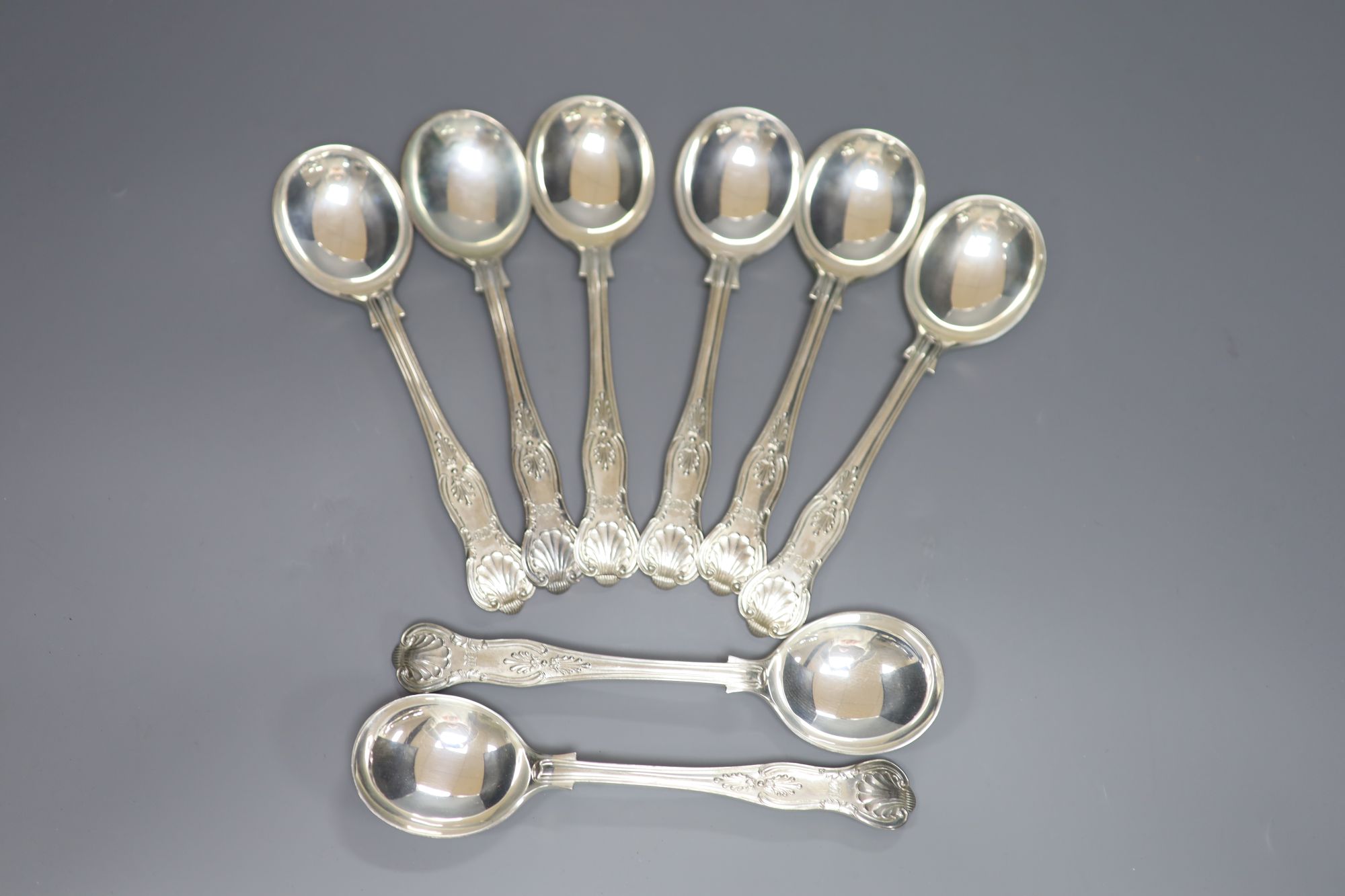 A set of eight George V silver Kings pattern soup spoons, Walker & Hall, Sheffield, 1933, 23.25oz.